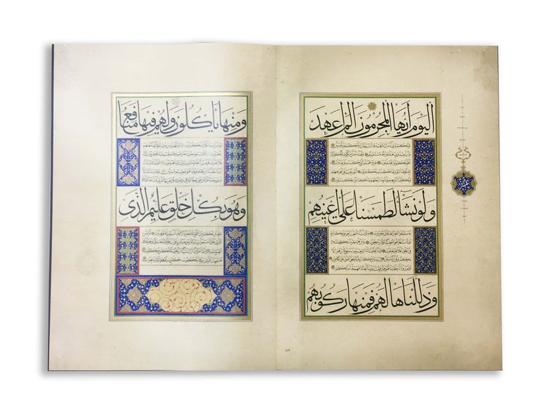 K&ouml;nnte beinhalten: Ein aufgeschlagenes Buch mit zwei Seiten komplexer arabischer Kalligrafie in schwarzer Tinte. Der Text ist von verzierten R&auml;ndern in Blau, Gold und Rot umrahmt, wobei florale und geometrische Muster die zentralen Schriftabschnitte umgeben.