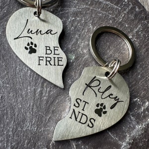 May include: Two silver heart-shaped keychains with engraved paw prints and the text "Luna Be Frie" and "Riley St Nds".