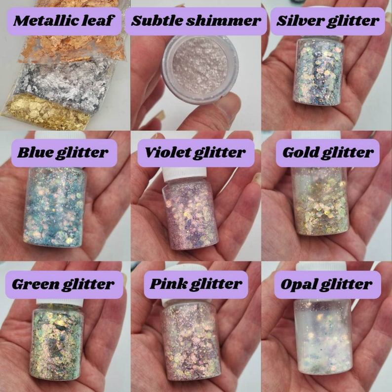 May include: Nine small glass jars filled with various glitter and metallic flakes. The jars are labeled with the following: Metallic leaf, Subtle shimmer, Silver glitter, Blue glitter, Violet glitter, Gold glitter, Green glitter, Pink glitter, and Opal glitter.