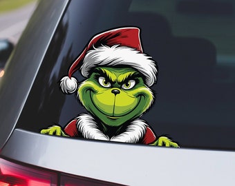 Może przedstawiać: Zielony Grinch w czerwonym kapeluszu Świętego Mikołaja wyglądający z okna samochodu. Grinch uśmiecha się przebiegle.