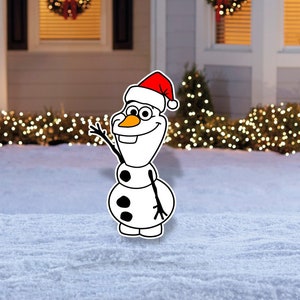 May include: A white snowman with a red Santa hat and black eyes and buttons stands in front of a house decorated for Christmas. The house has a red door and is lit with white Christmas lights.