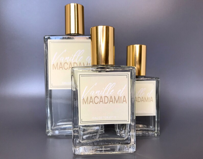 Three glass bottles of perfume, 50ml, 100ml and 30ml with gold caps and labels that say "Vanille et Macadamia". Nutty Vanilla perfume