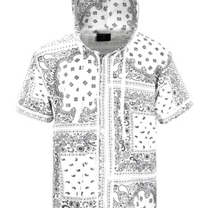 K&ouml;nnte beinhalten: Wei&szlig;es kurz&auml;rmeliges Kapuzenshirt mit schwarzem Paisley-Muster. Das Shirt hat einen durchgehenden Rei&szlig;verschluss und eine Kapuze mit Kordelzug. Das Paisley-Design wiederholt sich auf dem Stoff.