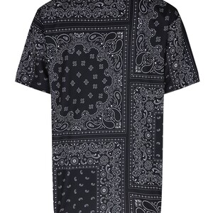 K&ouml;nnte beinhalten: Schwarzes Kurzarm-T-Shirt mit Paisley-Bandana-Muster. Das Shirt hat ein sich wiederholendes Design aus wei&szlig;en Paisley-Motiven auf schwarzem Hintergrund. Das Muster ist im Patchwork-Stil angeordnet und erzeugt ein visuell interessantes Design.