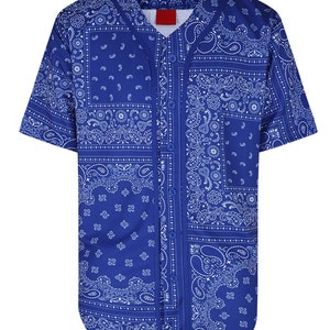 K&ouml;nnte beinhalten: Ein kurz&auml;rmeliges Baseball-Trikot in Blau mit wei&szlig;em Paisley-Muster. Das Trikot hat eine Knopfleiste und ein rotes Etikett am Kragen. Das Paisley-Muster ist in einem Patchwork-Stil angeordnet.