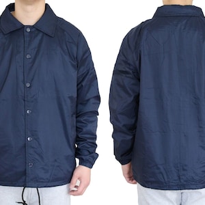 Op de afbeelding: Een lichtblauw jack met knopen en lange mouwen. Het jack heeft een klassieke coach-jack stijl.