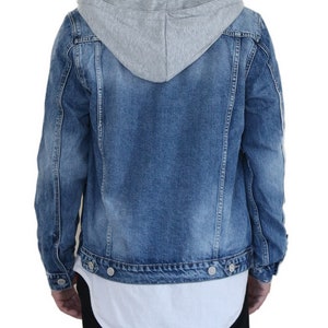 Pu&ograve; includere: Una giacca di jeans blu con una fodera con cappuccio grigia. La giacca ha una chiusura con bottoni e due tasche anteriori.
