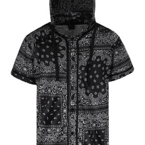 K&ouml;nnte beinhalten: Schwarz-wei&szlig;es Kapuzenshirt mit Paisley-Print und kurzen &Auml;rmeln. Das Shirt hat eine Knopfleiste vorne und eine Kapuze mit Kordelzug. Das Paisley-Muster ist ein klassisches Design, das dieses Shirt zu einer vielseitigen Erg&auml;nzung f&uuml;r jede Garderobe macht.