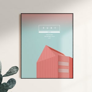 Peut inclure: Impression d'art encadrée présentant une illustration minimaliste d'un bâtiment aux tons corail et pêche sur un fond dégradé turquoise et rose. Le mot "RUBY" est affiché en haut, avec du texte supplémentaire en dessous.