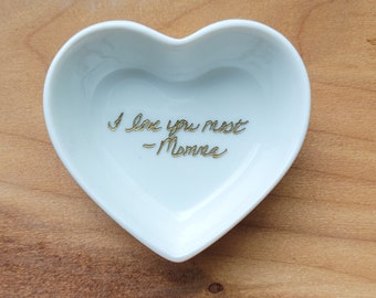 May include: White heart-shaped ceramic dish with gold lettering that reads "I love you most - Momma".