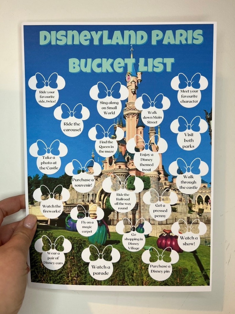 May include: A printable Disneyland Paris bucket list with a picture of Sleeping Beauty's castle in the background. The list includes activities like riding the carousel, taking a photo at the castle, watching fireworks, and going shopping in Disney Village.