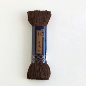 May include: A spool of brown embroidery floss with a blue label that reads "中  糸 (40)" in Japanese characters.