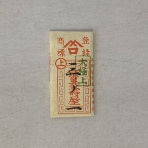 May include: A small, rectangular, cream-colored paper packet with red and black Chinese characters. The text reads "Shang Bai Jin" and "Da Zuo Shang".