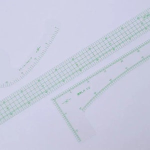 May include: Four clear plastic rulers with green markings. The rulers are for sewing and include a curved ruler, a straight ruler with a grid pattern, a straight ruler with a grid pattern and a right angle, and a straight ruler with a curved edge.