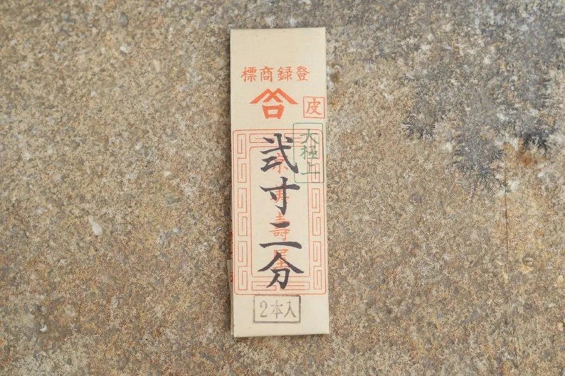 May include: A brown paper package with Japanese text that reads "精香舗" (Seikouho) and "寿香" (Juka) with a red seal that says "合" (Go). The package also says "2本入" (2 Hon Iru) which means "2 pieces included".
