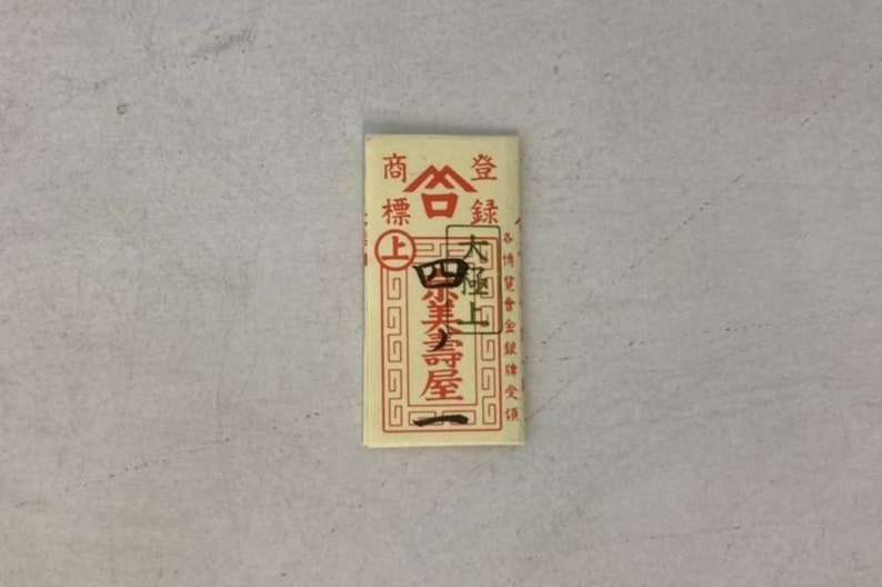 May include: A red and white paper envelope with Chinese characters that read "Shang Bai Jin" and "Da Bai Shang".
