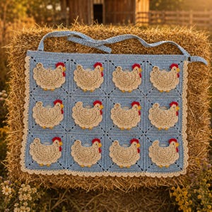 Peut inclure: Un tablier en crochet bleu clair composé d'une grille de douze panneaux carrés, chacun orné d'un motif de poule en crochet beige. Les poules ont des crêtes rouges et des becs jaunes. Le tablier est bordé d'une bordure festonnée crème.