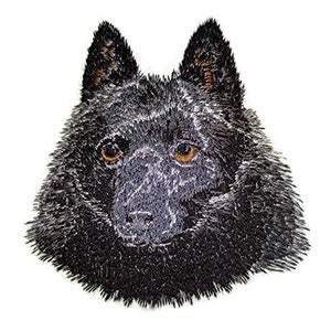 May include: Embroidered patch of a black wolf with brown eyes. The wolf's fur is detailed with a fluffy texture.
