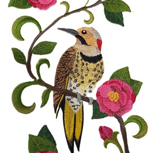 Peut inclure: Broderie d'un oiseau perché sur une branche, entouré de fleurs roses et de feuilles vertes. L'oiseau a un corps jaune et marron, un bec noir et des plumes de queue jaunes. Les fleurs ont des centres jaunes.
