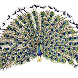 Könnte beinhalten: Gestickter Pfauen-Patch mit blauem und grünem Schwanz, goldenen Akzenten und weißem Hintergrund.