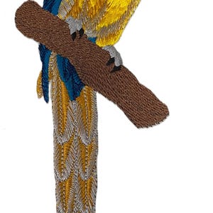 Peut inclure: Écusson brodé représentant un perroquet ara sur une branche marron. L'oiseau a un plumage bleu, jaune et vert, un bec noir et un visage blanc. Le patch est conçu pour être appliqué sur du tissu.