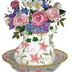 May include: A white ceramic pitcher with floral designs, filled with a bouquet of pink, purple, and white flowers. The pitcher is sitting on a white plate with a floral design.