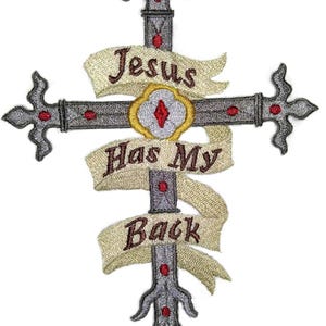 May include: Embroidered cross with the text "Jesus Has My Back" on a cream-colored banner. The cross is gray with red accents and decorative flourishes. A gold and red emblem is at the center.
