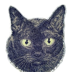 Op de afbeelding: Gestikt zwart kattengezicht patch met gele ogen. De patch is perfect om een ​​toets van whimsy toe te voegen aan kleding, tassen of andere accessoires.