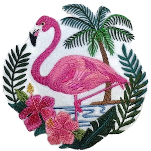 Pode incluir: Um emblema bordado apresentando um flamingo rosa brilhante em pé sobre uma perna. A cena inclui uma palmeira marrom, folhas tropicais verde-escuras e duas grandes flores de hibisco rosa com centros amarelos sobre um fundo branco.