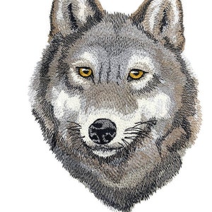 以下が含まれることがあります： 灰色と茶色の毛皮のパターンを持つオオカミの頭のクローズアップ。オオカミは黒い鼻と明るい黄色の目をしています。