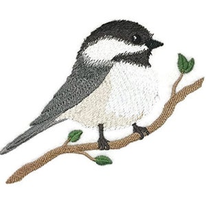 May include: Embroidered black and white chickadee bird perched on a brown branch with green leaves.