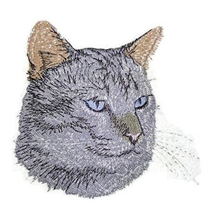 Puede incluir: Gato gris bordado con ojos azules. La cabeza del gato está mirando hacia el lado derecho de la imagen. Las orejas del gato son marrones y el fondo es blanco.