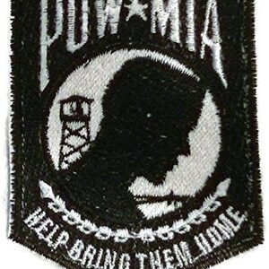 Op de afbeelding: Zwart-wit geborduurde patch met de woorden "POW MIA" en "Help Bring Them Home". De patch toont een silhouet van een krijgsgevangene voor een wachttoren.