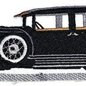 Könnte beinhalten: Schwarz-weiß gestickter Aufnäher eines Oldtimers. Das Auto hat eine schwarze Karosserie, weiße Räder und eine braune Windschutzscheibe.