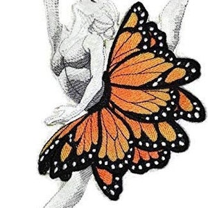 May include: A white ballerina with a butterfly wing costume. The wings are orange and black with a detailed pattern.