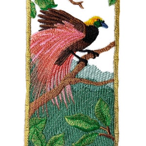 May include: Embroidered patch of a bird of paradise with a yellow head and pink and brown feathers, perched on a branch with green leaves in a gold frame.