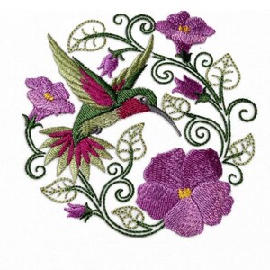 May include: An embroidered patch featuring a hummingbird with green and magenta wings and tail feathers, surrounded by a circular arrangement of purple flowers and dark green swirling vine patterns with small outlined leaves.
