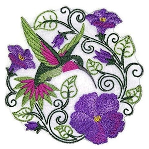 Puede incluir: Parche bordado para planchar con un colibrí verde con detalles rosas volando a través de un arreglo floral de flores moradas y hojas verdes.