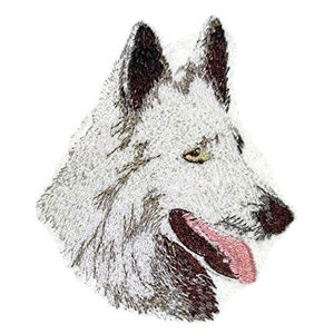 Puede incluir: Cabeza de lobo blanco bordada con orejas marrones y una lengua rosa. El lobo mira hacia la derecha.