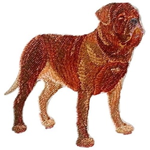 May include: Embroidered patch of a brown and tan dog with a short, cropped tail. The dog is standing with its head turned to the side.