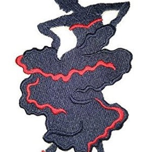 Puede incluir: Parche bordado para planchar con la silueta de una bailarina de flamenco con un vestido negro y ribetes rojos. La bailarina está en medio de una pose con los brazos extendidos.