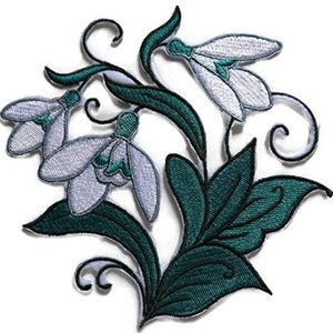 以下が含まれることがあります： 白いスノードロップの花が緑の葉と茎で集まっている、アイロン接着の刺繍パッチ。花は繊細で詳細なデザインです。