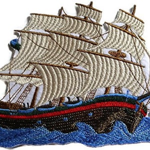 May include: Embroidered patch of a white sailing ship with brown masts and a blue and red hull. The ship is sailing on blue waves.