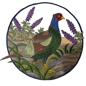 Peut inclure: Écusson brodé représentant un faisan dans un cadre naturel. L'oiseau a une tête bleue, un visage rouge et un corps vert, entouré de fleurs violettes et d'herbe verte. L'écusson est circulaire avec une bordure bleu foncé.