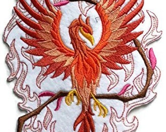 Puede incluir: Parche bordado para planchar con un fénix rojo y naranja que se eleva de las llamas con un diseño de vid marrón. El fénix está rodeado de llamas rosas y blancas.