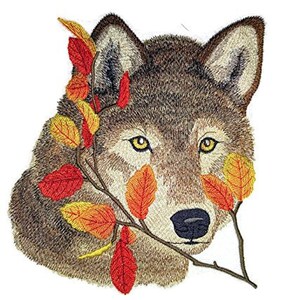 May include: Embroidered patch of a wolf's face with autumn leaves and branches. The wolf has brown fur and yellow eyes. The leaves are red, orange, and yellow.