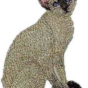 Puede incluir: Un gato siamés beige con ojos azules sentado sobre un fondo blanco. El gato tiene una cola larga y mira hacia la derecha.