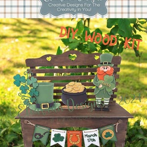 May include: A wooden DIY kit featuring a leprechaun, a pot of gold, a shamrock, a hat, and a banner with the text "March 17th".
