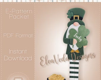 Puede incluir: Un patrón de descarga digital para un proyecto de artesanía de gnomo leprechaun. El gnomo lleva un sombrero verde, una chaqueta verde y pantalones a rayas. Sostiene un trébol que dice "lucky". El gnomo está de pie junto a una olla de monedas de oro.