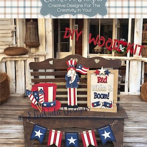 May include: A DIY wood kit for a patriotic themed decoration. The kit includes a wooden sign with the text "Red White & Boom!" and a wooden gnome wearing a red, white, and blue hat and holding a flag. There is also a wooden hat with a red, white, and blue design and a banner with red, white, and blue stars.